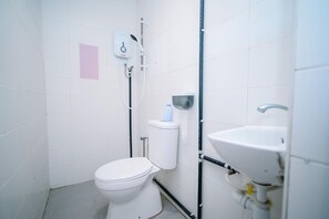 A small, white bathroom with a toilet, a hand dryer, and a sink. - Swing & Pillows at Penang Road, Georgetown (Northeast Penang Island)