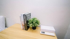 A wooden table with a book titled 'Tom Ford' and a small potted plant. - Swing & Pillows at Penang Road, Georgetown (Northeast Penang Island)