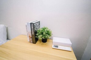 A wooden table with a book titled 'Tom Ford' and a small potted plant. - Swing & Pillows at Penang Road, Georgetown (Northeast Penang Island)