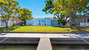 A two-story house with a front yard, a small pool, and a white picket fence. - Waterfront Retreat W / Floating Dock & Kayaks (New Port Richey)