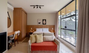 A hotel room with a bed, bedside tables, a chair, a fireplace, and a large window with a view of the outside. - House w/ Fireplace and Bathtub in Urubici Cla0000 (Urubici)