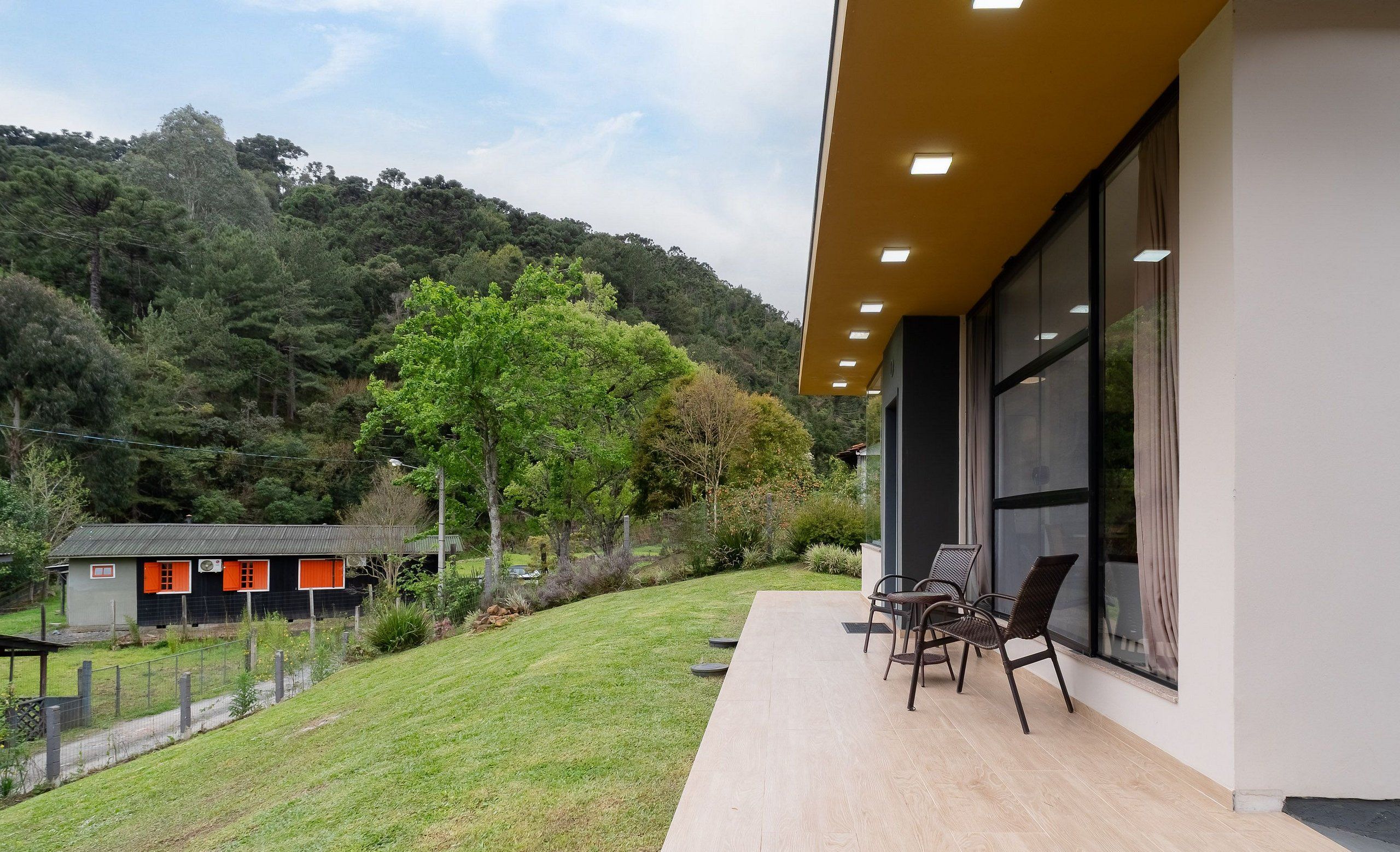 A modern building with a patio area featuring outdoor seating.
