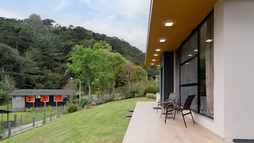 A modern building with a patio area featuring outdoor seating.