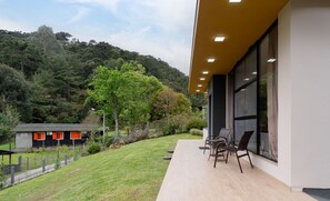 A modern building with a patio area featuring outdoor seating. - House w/ Fireplace and Bathtub in Urubici Cla0000 (Urubici)