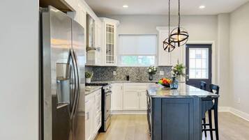 Full kitchen on the first floor with stove, oven, microwave, refrigerator, coffee maker, and other cooking essentials