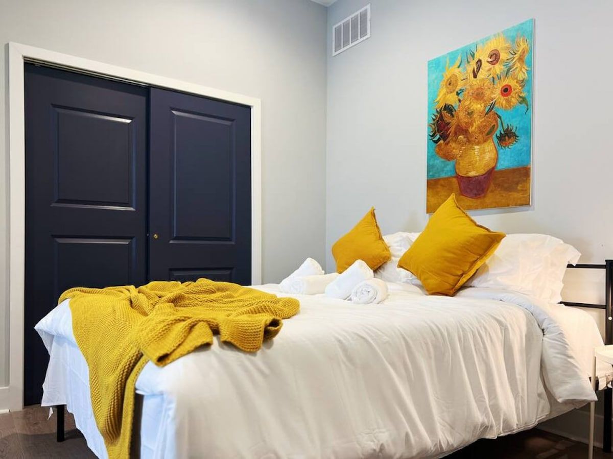 Una habitación de hotel con cama, un cuadro y un armario.