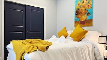 Una habitación de hotel con cama, un cuadro y un armario.