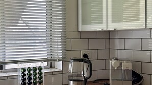 A kitchen with a coffee maker, a kettle, and a wine rack.