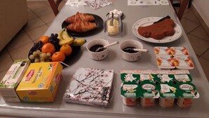Ruokapöytä, jonka päällä on ruokaa, juomia ja pakattuja elintarvikkeita.