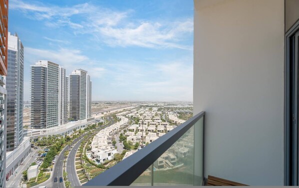 A high-rise building with a view of a residential area and a curved road.