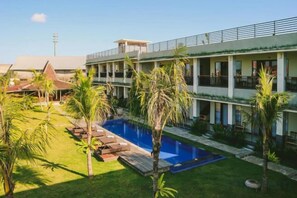 Un hôtel doté d’une piscine, de plusieurs balcons et d’une pelouse bien entretenue.