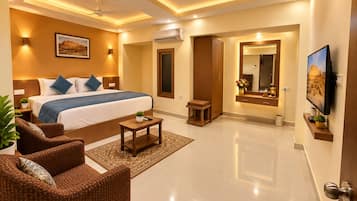 A modern hotel room with a large bed, a sitting area with a chair, a small table, and a TV.