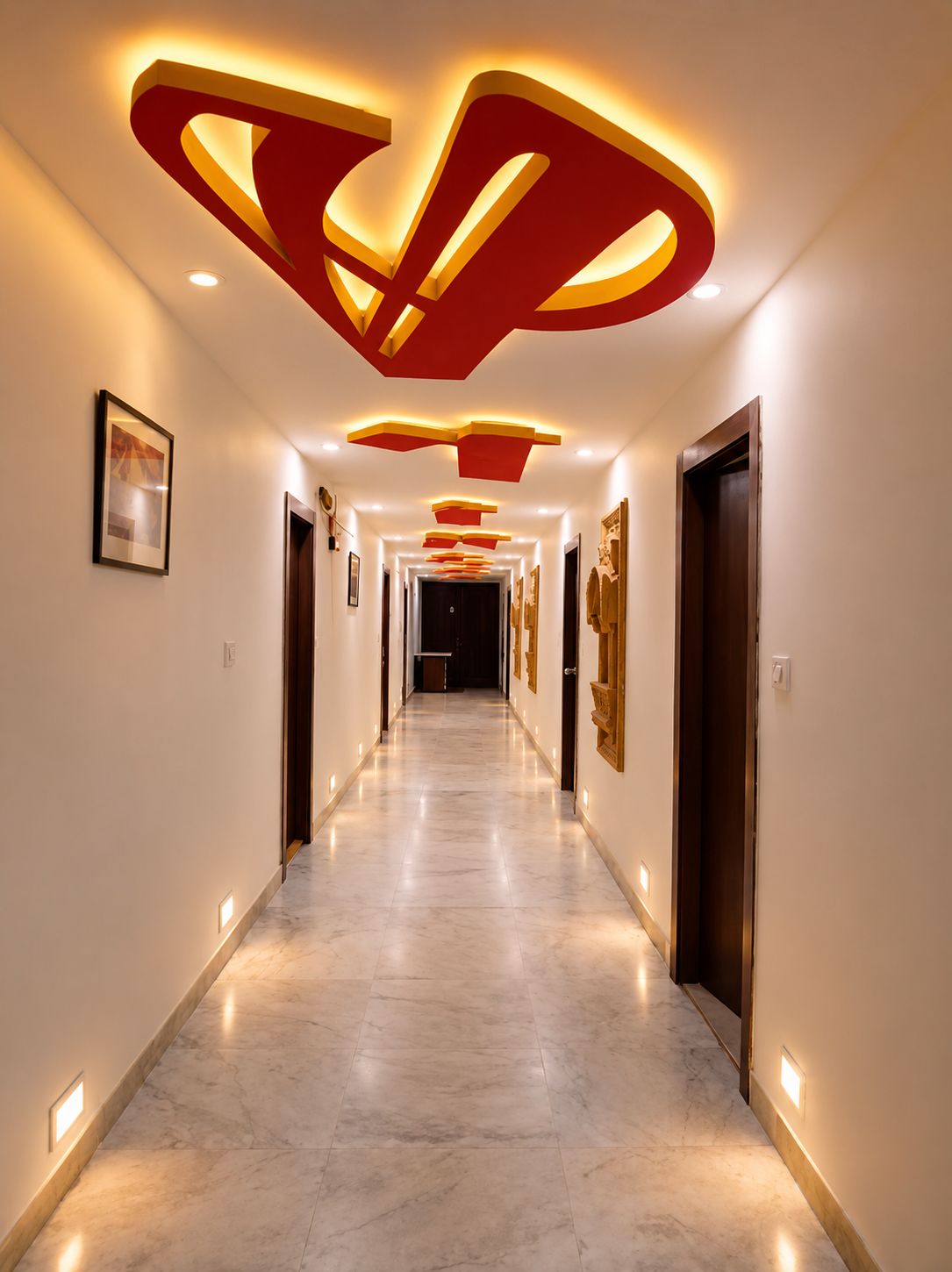 A hallway with a modern design, featuring recessed lighting and a marble floor.