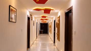 A hallway with a modern design, featuring recessed lighting and a marble floor.
