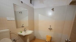 Un baño pequeño con inodoro, lavamanos y espejo.