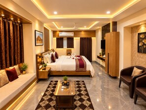 Une chambre d’hôtel moderne avec un grand lit, un canapé, une table basse et un téléviseur.