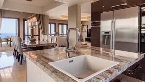 Una cocina moderna con una isla grande, electrodomésticos de acero inoxidable y vista al área de comedor.