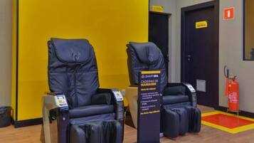 A room with two massage chairs and a sign indicating a 5-minute relaxation period.