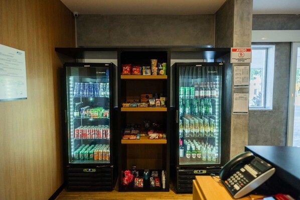 A vending machine area with three refrigerated units, a phone, and a window with a view. - Blue Tree Towers Sorriso (Sorriso)