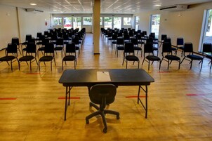 Un amplio espacio interior con filas de sillas y mesas, presumiblemente una sala de conferencias o área de reuniones.
