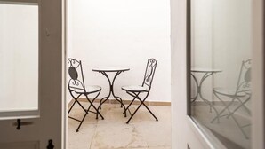 A small room with two metal folding chairs and a small round table. - Palazzo Celina (Gallipoli)