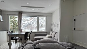 A modern bedroom with a large bed, a dining table, and a sofa. - New Studio | Dream Views • Balcony • Free Parking (Leukerbad)