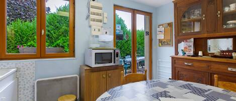 A kitchen with a microwave, a sink, and a window overlooking greenery.