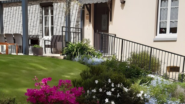 Un jardin bien entretenu, agrémenté de diverses plantes à fleurs et d’une pelouse soigneusement taillée.