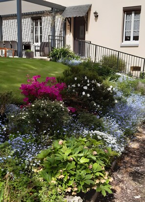 A well-maintained garden with various flowering plants and a neatly trimmed lawn. - Guest Room 'Chambre Lecarpentier - Coquelicot' with Shared Terrace, Shared Garden, Wi-Fi (Fontenay)