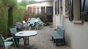 Une terrasse avec des meubles d’extérieur, une table et des chaises.