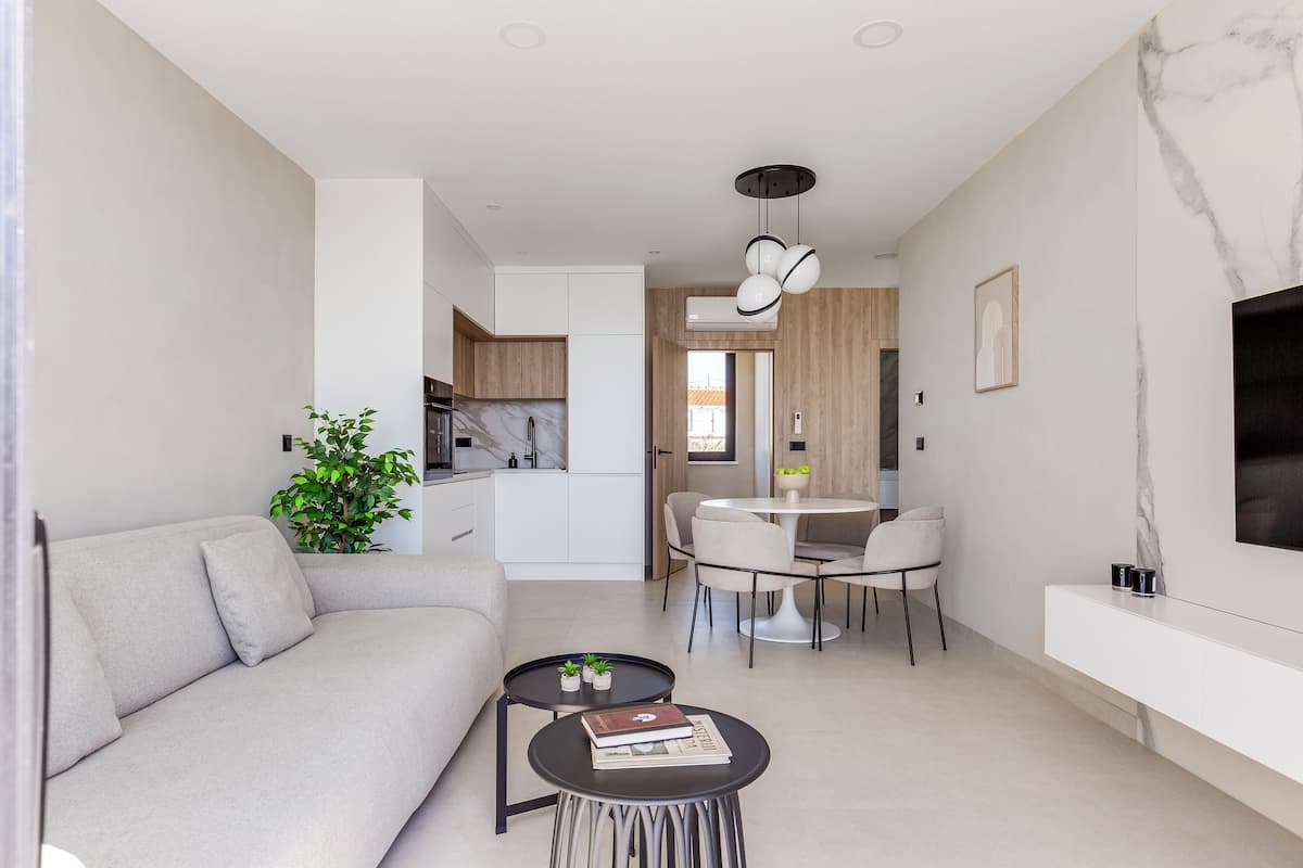 A modern living space with a sofa, a dining table, and a TV.