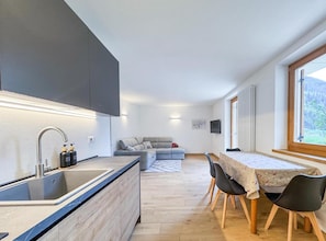 A modern kitchen with a built-in sink and a dining area with a table and chairs.