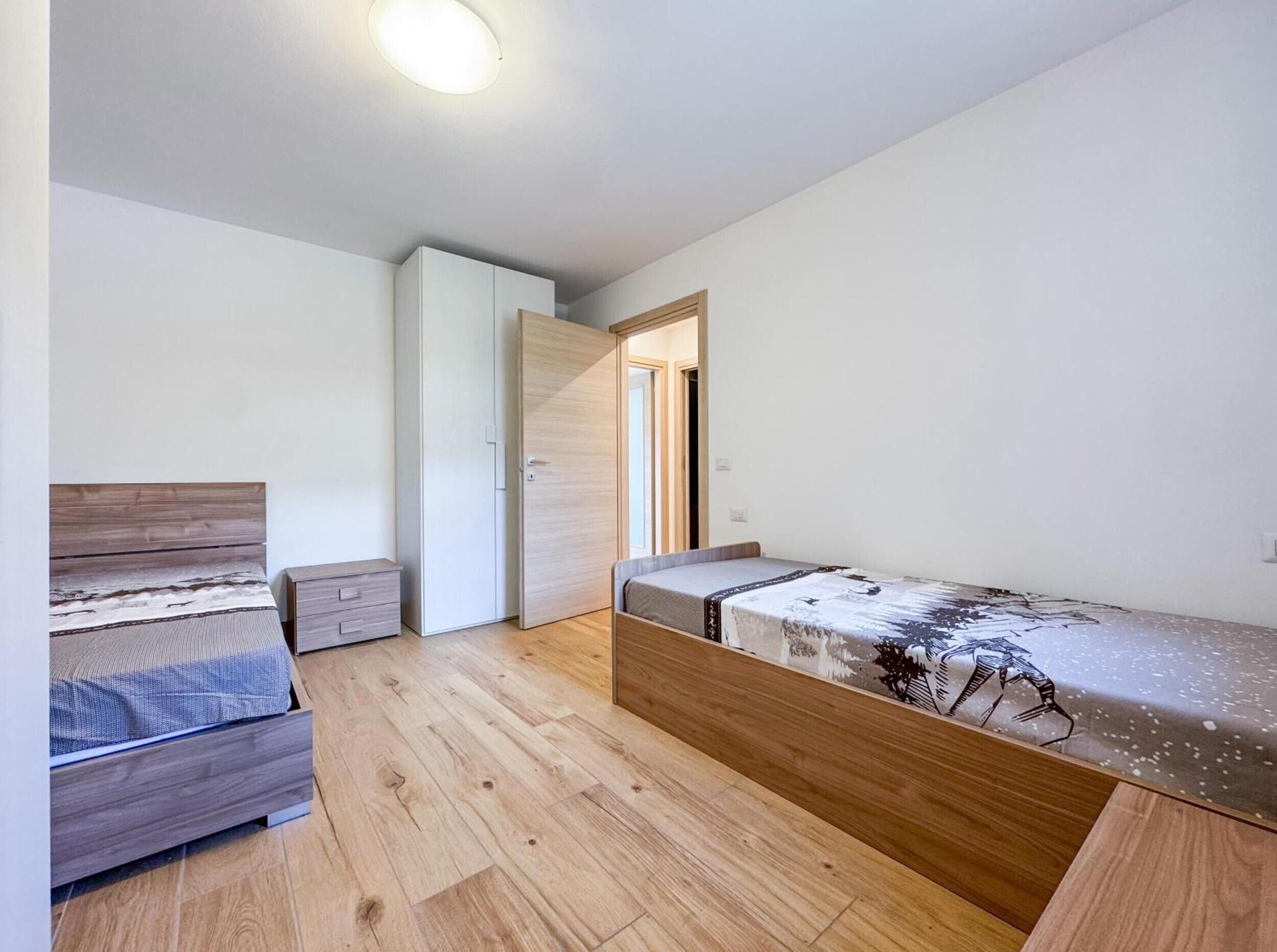 Una camera da letto con un letto, un armadio, una scrivania e una finestra.