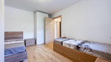 Una camera da letto con un letto, un armadio, una scrivania e una finestra.
