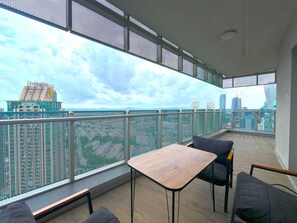 A balcony with a view of a city skyline, a wooden table, and black chairs. - Maslak 1453 Grand Panorama (Sariyer)