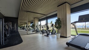 A gym with exercise equipment, large windows, and a view of the outdoors. - SUNSET SAILORS sweet apartment (Benidorm)