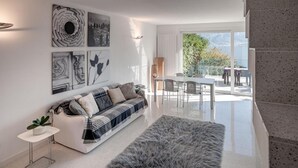 Un salon moderne avec un canapé, un tapis et des œuvres d’art accrochées au mur.