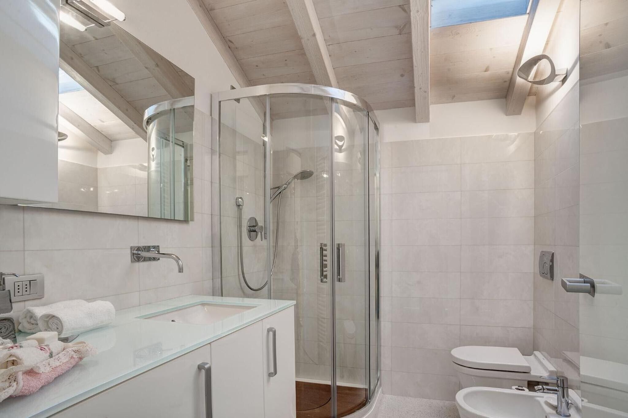 Une salle de bain moderne avec une douche à parois de verre, un lavabo en verre et des toilettes.
