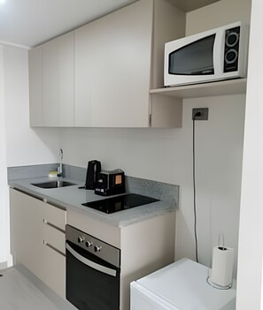 A modern kitchen with a built-in microwave, a coffee maker, and a dishwasher. - Edificio Stepke (Temuco)