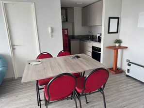 A compact kitchen with a microwave, refrigerator, and sink. - Edificio Stepke (Temuco)