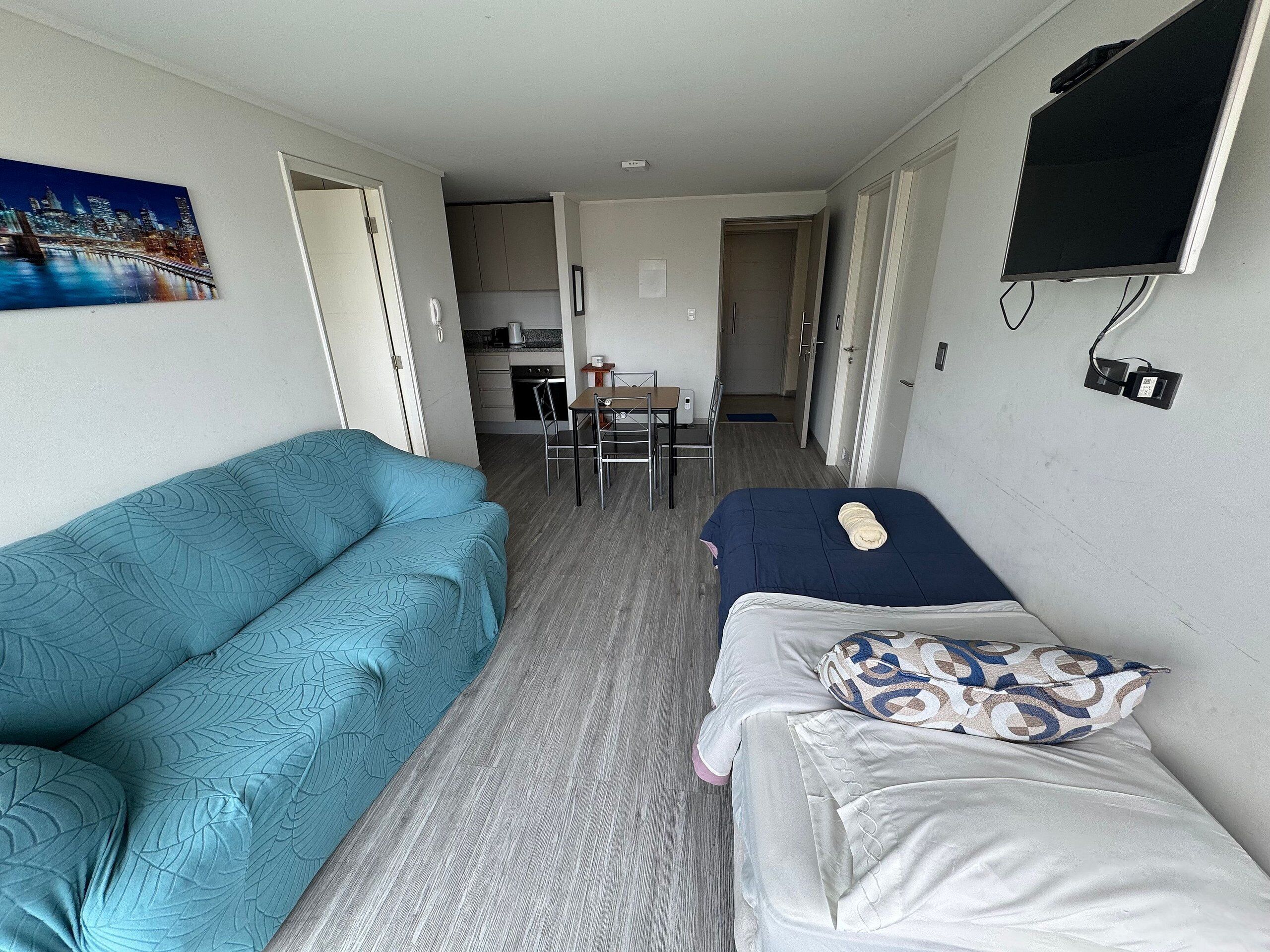 Una habitación con dos camas, kitchenette y comedor.