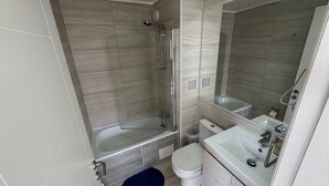 Ein modernes Badezimmer mit Badewanne, Dusche, Toilette und Waschbecken.