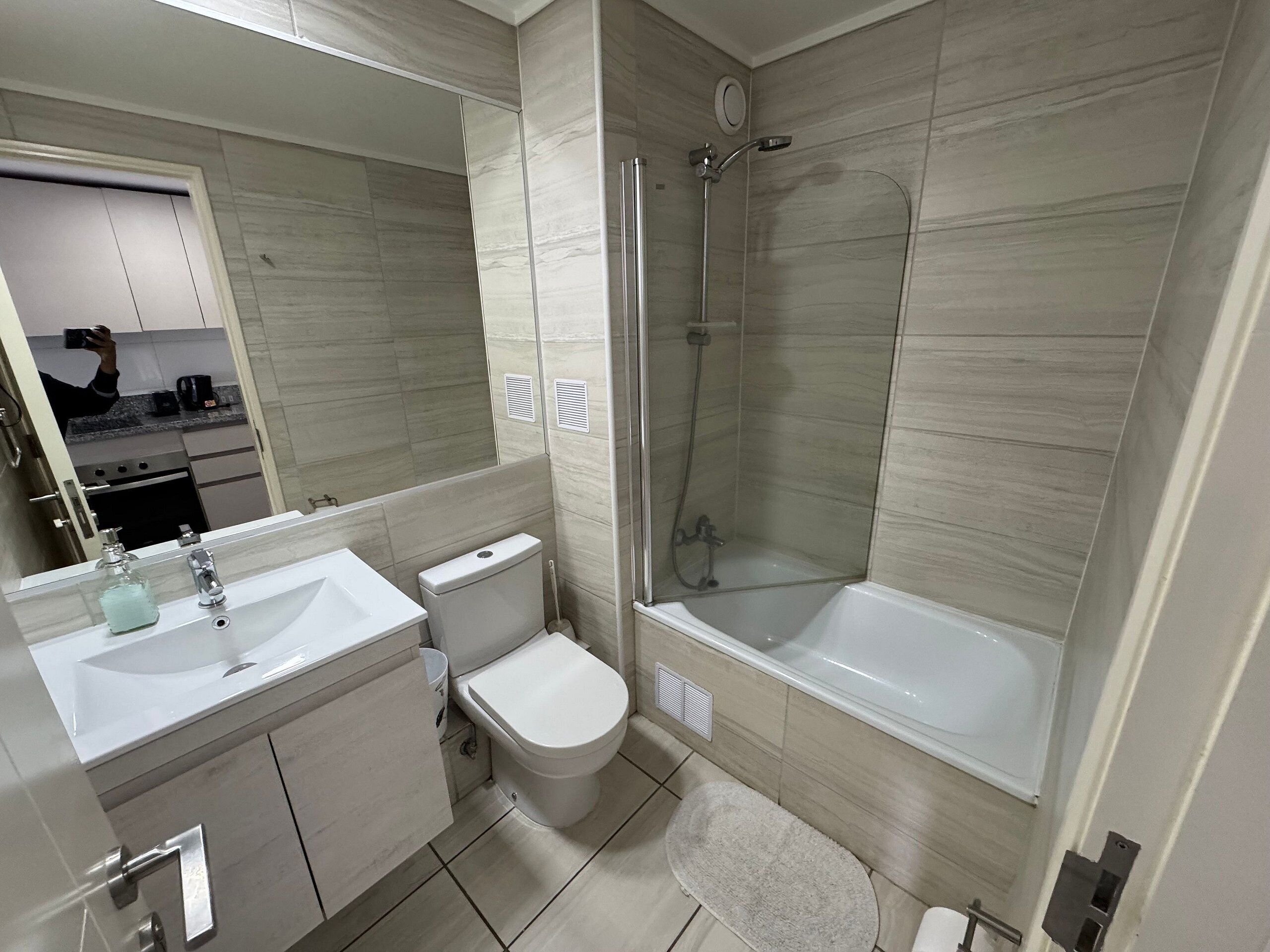 Un baño moderno con lavamanos, inodoro, ducha y bañera.