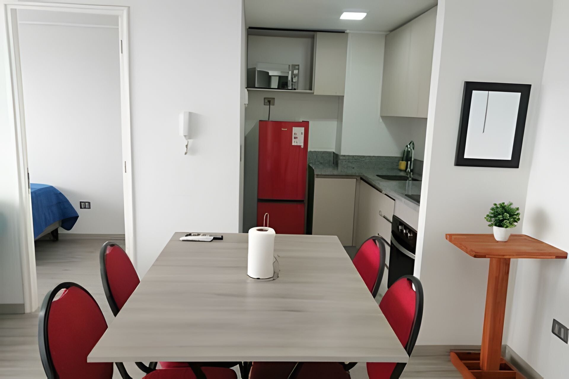Een kleine keuken met een koelkast, gootsteen en aanrecht.