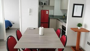 Eine kleine Küche mit Kühlschrank, Spüle und Arbeitsplatte.