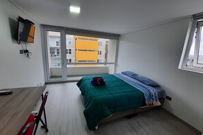 Una camera da letto con un letto, una scrivania e una finestra.