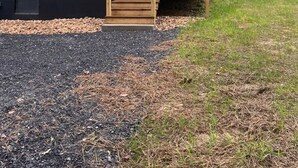 Uma cabana de dois andares com uma escadaria de madeira que leva a um deck.