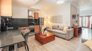 A modern living room with a sofa, coffee table, and a dining area with chairs and a table. - Studio 3 Guests Balcony With Views Fishing Lodge (Punta Cana)
