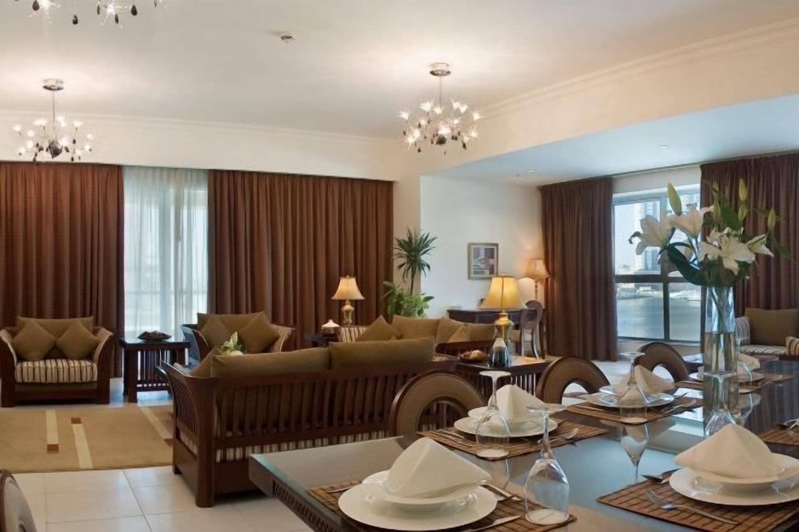 Sala de hotel com sofá, mesa de jantar e objetos decorativos.