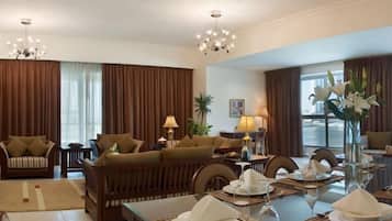 Sala de hotel com sofá, mesa de jantar e objetos decorativos.